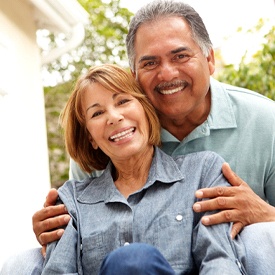 Older couple with dental implant supported dentures smiling together